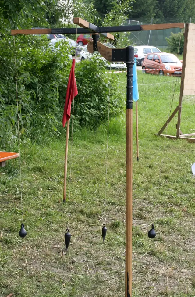 Nachbau einer Groma: senkrechter Stab mit waagerechtem Kreuz, an dessen Enden Lote an Schnüren hängen