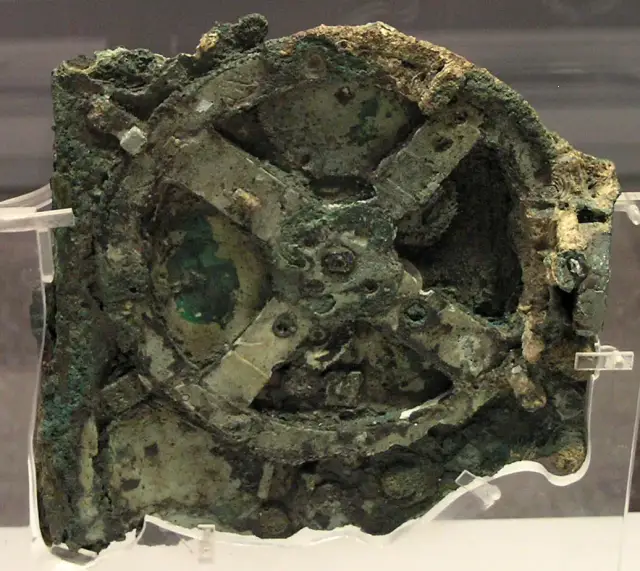 Stark korrodiertes Bronzefragment mit sichtbaren Zahnrädern, ausgestellt im Nationalmuseum Athen